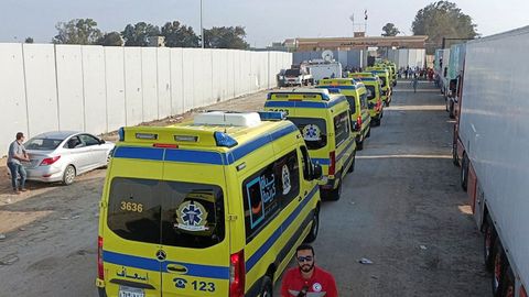 Decenas de ambulancias egipcias esperan para cruzar el paso fronterizo de Rafah, que separa su país con Gaza
