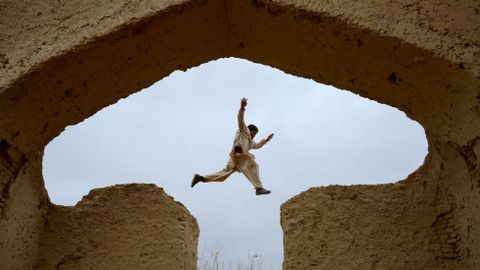 Un nio afgano juega entre las ruinas de una casa en Mazar-i-Sharif.