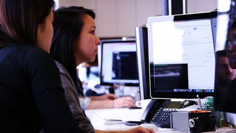 Dos estudiantes consultan un ordenador en una imagen de archivo