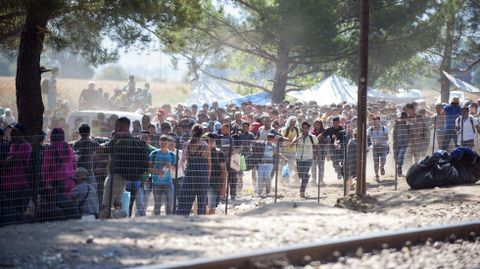 Colas de inmigrantes junto a la polica de Macedonia esperando que les dejen pasar en la frontera entre Grecia y Macedonia