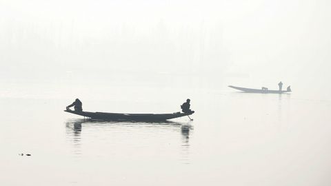 Varios pescadores faenan en un da de niebla en India. 