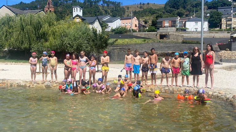 La alcaldesa, María del Carmen González, con los niños del campamento en las piscinas.