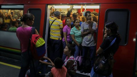 Personas aguardan la reanudación del Metro de Caracas después de una interrupción del servicio tras un corte de energía