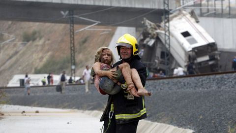Marta García, en brazos de un bombero, poco después del descarrilamiento del Alvia en Angrois