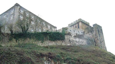 Tramo de la antigua muralla medieval perteneciente a Paradores, con la Torre dos Cregos a la derecha y en primer término