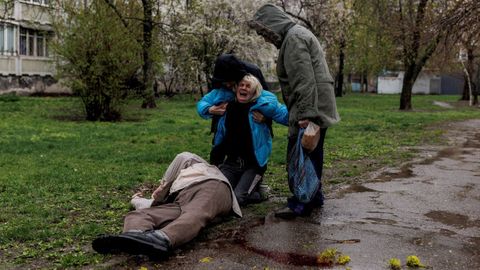 A woman cries over the body of her father who was killed by Russian forces in Kharkiv, Ukraine.