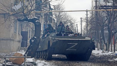 Los miembros del servicio de las tropas prorrusas se ven encima de un vehículo blindado con los símbolos  Z  pintados en un costado en el transcurso del conflicto Ucrania-Rusia en la ciudad portuaria sureña sitiada de Mariupol.