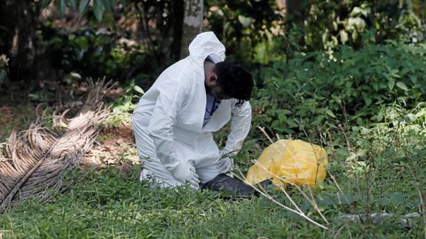 Un funcionario de salud acaba en el suelo mientras recolectaba muestras de los aldeanos durante el toque de queda, en Colombo, Sri Lanka