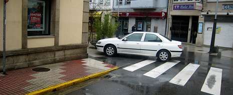 La presencia de coches mal aparcados en el centro de Sarria es muy habitual.