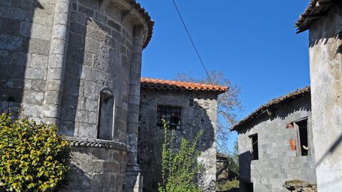 Construcción de cemento al lado de una iglesia románic aen O Saviñao.