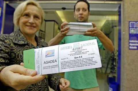 La presidenta de Agadea y un lotero muestran las papeletas con el texto sobre el gravamen.