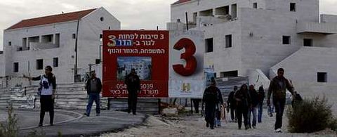 Una israel espera a que albailes palestinos salgan del asentamiento de Maale Adumin despus de un da de trabajo.