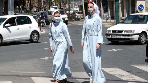 Dos monjas camina por Sarajevo ataviadas con mascarillas