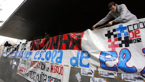 Un estudiante colgando carteles contra el plan Bolonia sobre la barandilla exterior de la Conchi en marzo del 2007.