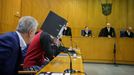 El acusado iraquí Taha A. J. cubriéndose el rostro con una carpeta antes de saber hoy el veredicto en el Tribunal Regional Superior de Frankfurt.