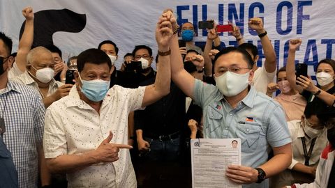 El presidente de Filipinas, Rodrigo Duterte, levanta la mano del senador filipino Christopher  Bong  Go despus de presentar su certificado de candidatura para las elecciones nacionales de 2022