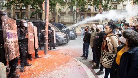 Los diputados de la CUP Carles Riera y Dolors Sabater, segunda y tercero a la derecha en la imagen, frente a unos agentes de los Mossos durante un deshaucio en Barcelona