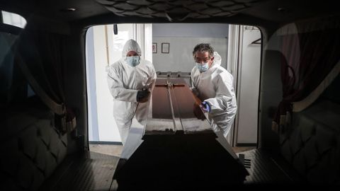 Trabajadores de funerarias transportan cadáveres en Portugal