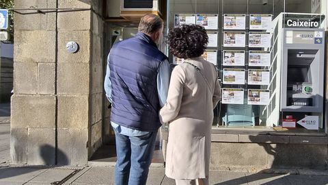 Pareja delante de una agencia inmobiliaria en Pontevedra