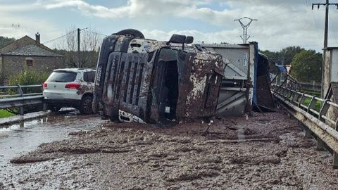 A causa de la colisión, el camión volcó sobre la carretera y su carga -transportaba lodos- quedó esparcida por la calzada