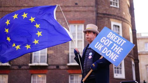 Un manifestante contra el brexit sostiene un cartel y la bandera de la UE  frente a Lancaster House, en Londres.