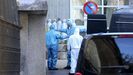 Trabajadores de servicios funerarios se desinfectan tras un traslado en una residencia de Santiago