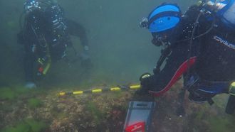 Arqueólogos documentando cañones hallados en el mar en Castropol
