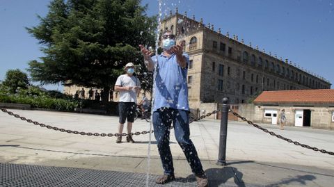 Un turista trata de refrescarse con el agua de una fuente junto al colegio de la Compaa, este viernes en Monforte