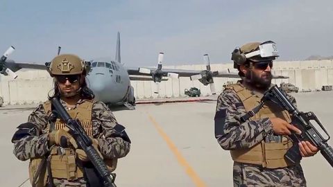 Miembros de la unidad militar montan guardia mientras el portavoz talibán pronuncia su discurso en el aeropuerto de Kabul
