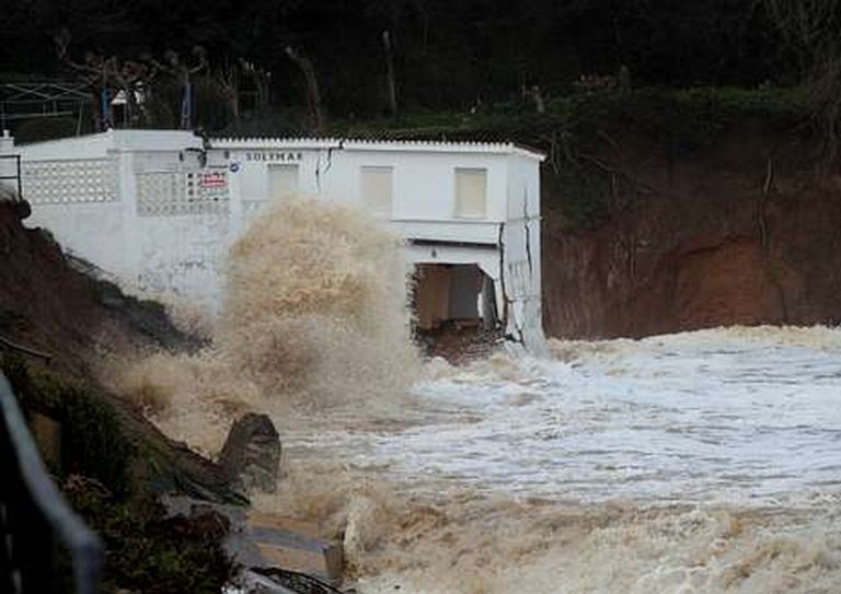 El agua acabó tirando la escalera de madera al tiempo que batía al castigado inmueble del arenal.