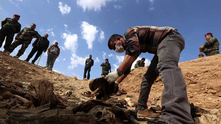 Un hombre de la minoría yazidí apila hallazgos en una fosa de la localidad de Sinuni