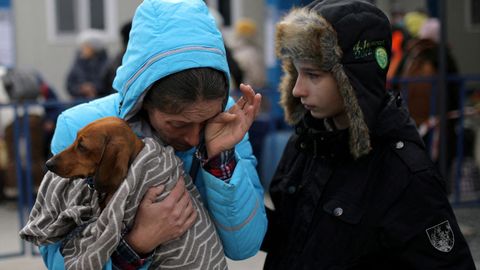 Yulia Vigrinyak, de Mykolaiv, llora con su perro en brazos tras su llegada en ferri en el paso fronterizo de Isaccea-Orlivka, en Rumanía