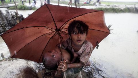 Un nio de la etnia musulmana rohiny protege a su hermana pequea de la lluvia en Teknaf (Bangladesh) 