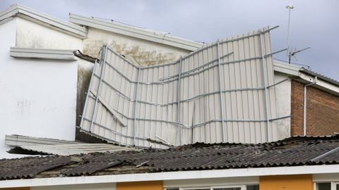 Una parte del tejado destrozado por el viento en el IES Ro Cabe cay a la calle y la otra quedo sobre el edificio