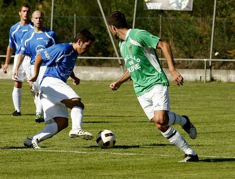 Un futbolista del Atl�tico Escair�n conduce el bal�n en el campo municipal de O Savi�ao.