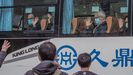 Los investigadores saludan desde el autobús durante en el primero y único viaje a Wuhan
