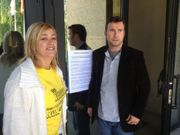 Dos funcionarios de Vigo colocan en una puerta de los juzgados un papel de convocatoria de la concentraci�n para ma�ana