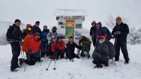 Un grupo de excursionistas junto a un panel informativo del bosque de la Devesa da Rogueira