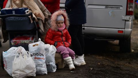 Una nia con las pertenencias de su familia en la frontera con Rumana 