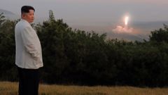 El presidente de Corea del Norte, Kim Jong-un, posando mientras, al fondo, se lanza un mil balstico durante unas maniobras de Pionyang con armas tcticas nucleares