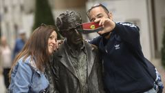 Turistas se fotografían con la estatua de Woody Allen, en Oviedo