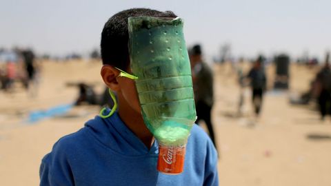 Un manifestante palestino se protege con un artilugio casero del gas lacrimgeno en la frontera de Gaza.