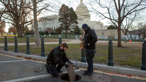 Agentes de la Policia del Capitolio inspeccionan y sellan una alcantarilla en los terrenos del edificio