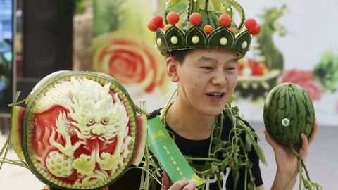 Un hombre lleva un sombrero hecho de monda de sanda en el festival anual de esta fruta en Pekn.