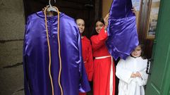 Unas monaguillas enseñan este jueves en la puerta de la iglesia monfortina de A Régoa uno de los hábitos que se ponen los nazarenos que acompañan la imagen del Ecce Homo en la procesión del Viernes Santo en Monforte