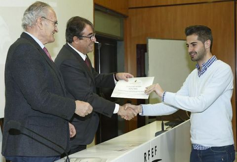 Jorge Pérez, secretario general de la federación española, en el centro, entrega el título a David Páez