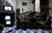 Un rebelde sirio se relaja viendo la televisin antes de entrar en combate.