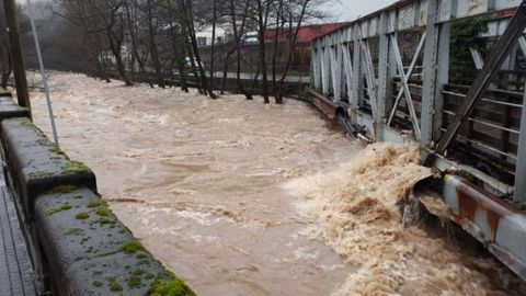 Crecida del r�o Trubia a su paso por un puente peatonal