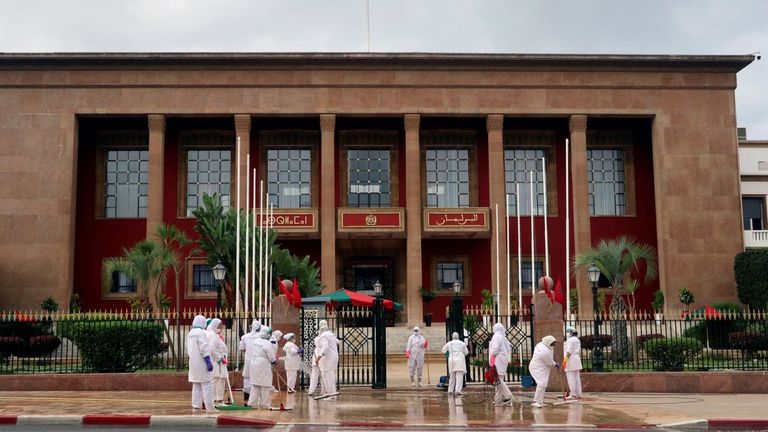 Una brigada de limpieza realiza su trabajo frente al Parlamento marroquí de Rabat