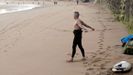 Un surfista realiza estiramientos antes de entrar al agua en la Playa de San Lorenzo de Gijón
